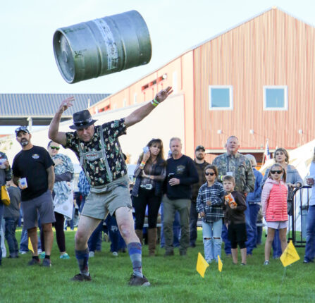 Man in lederhosen tossing a keg.