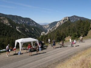 A tent along a dirt road overlooking the valley, with cyclists.