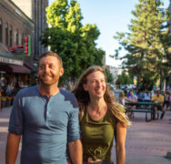 Male and female walking along downtown with big smiles