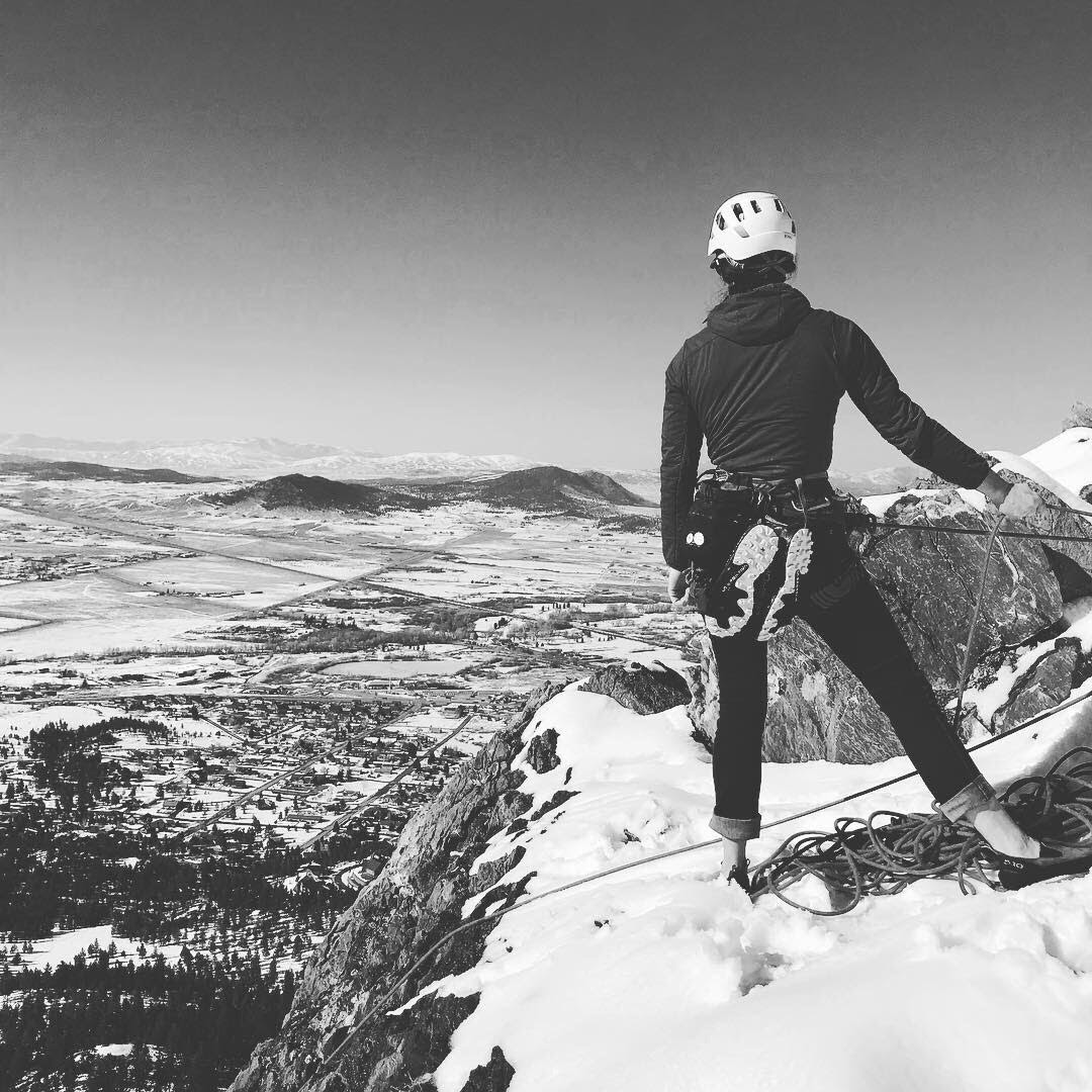 Black and white picture of a rock climber at the top